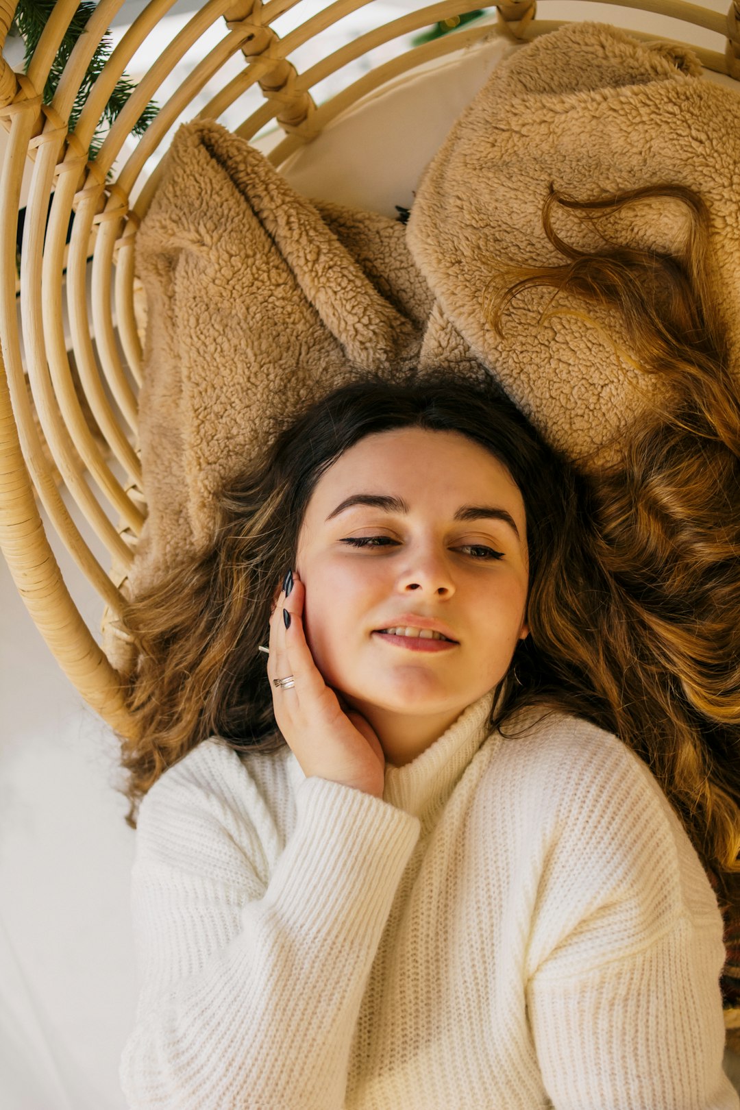 woman in white sweater lying on brown textile