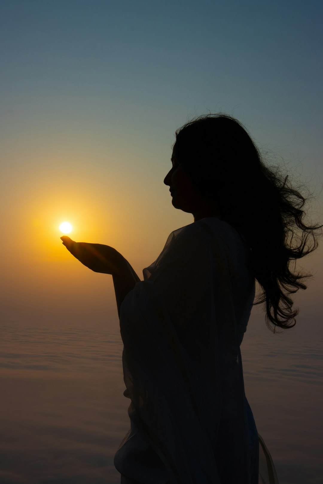 Woman holds the sun in her hands.