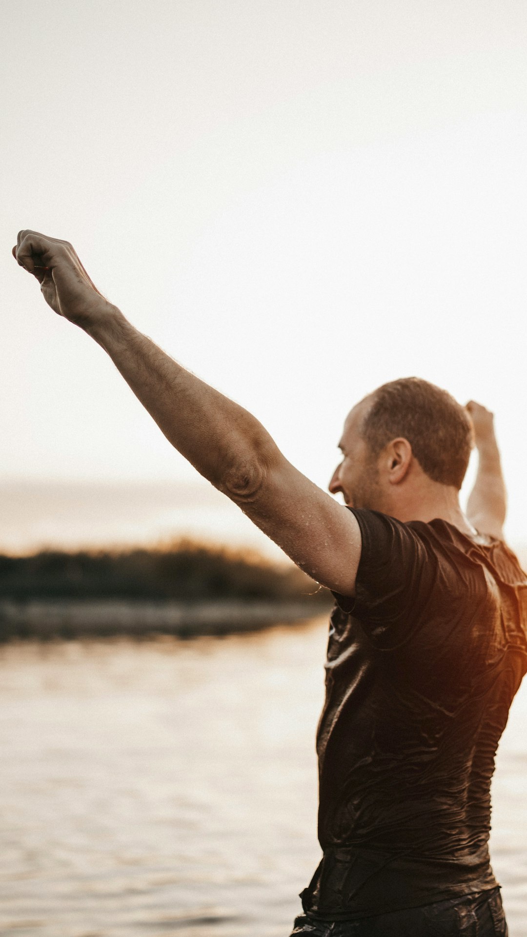 A man standing in the water with his arms in the air