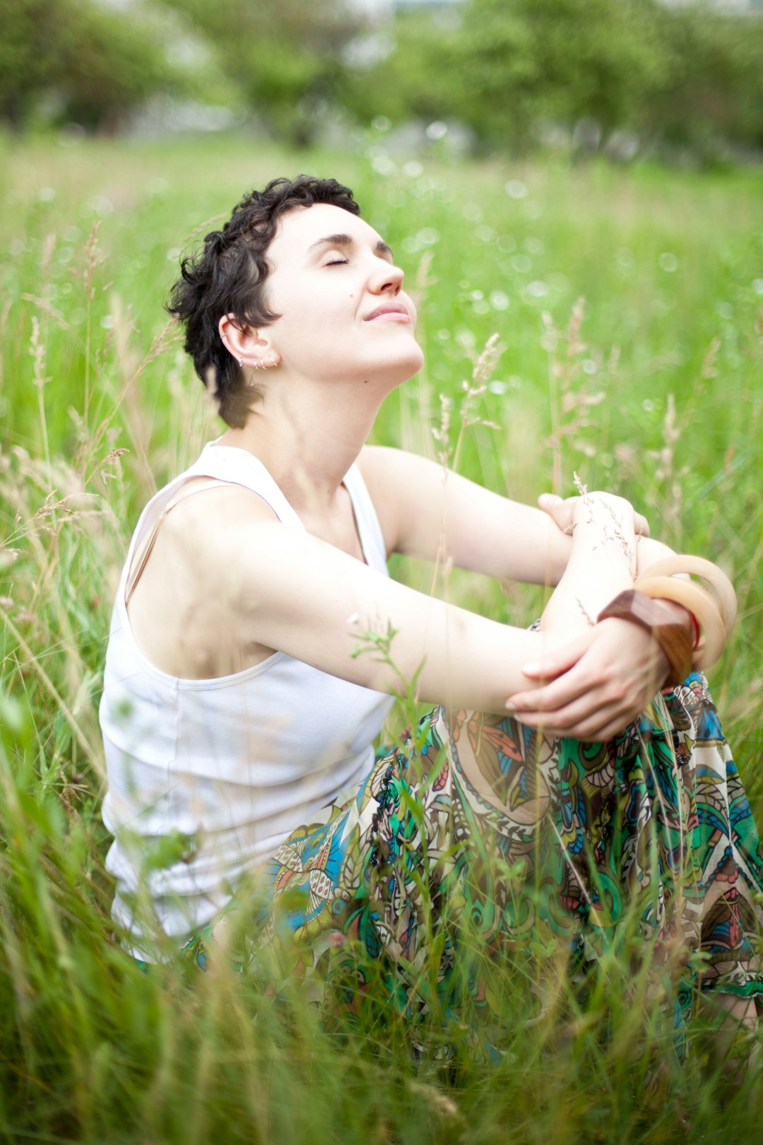 A woman sitting in a field of tall grass