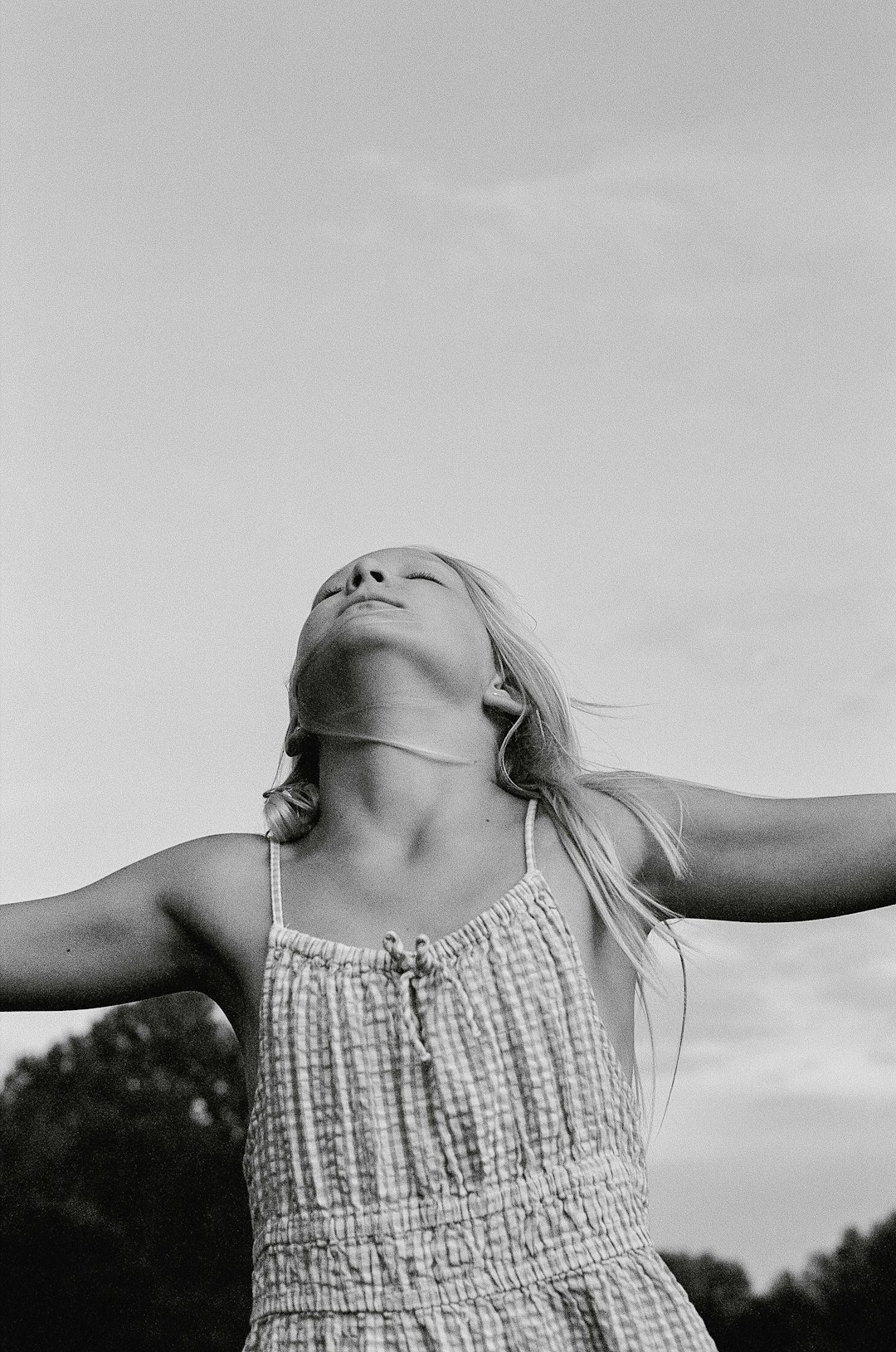 A woman in a dress is flying a kite