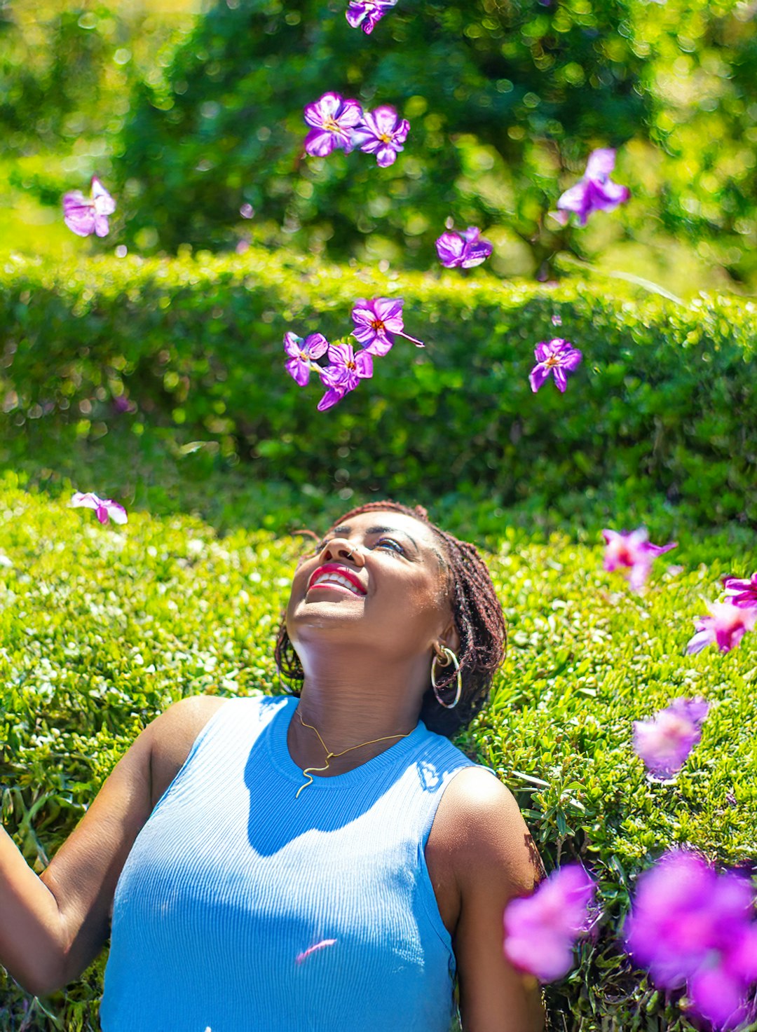 A woman laying on the ground in a field of flowers
