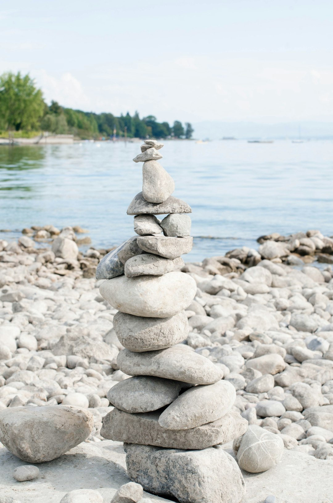 a large pile of rocks by a body of water