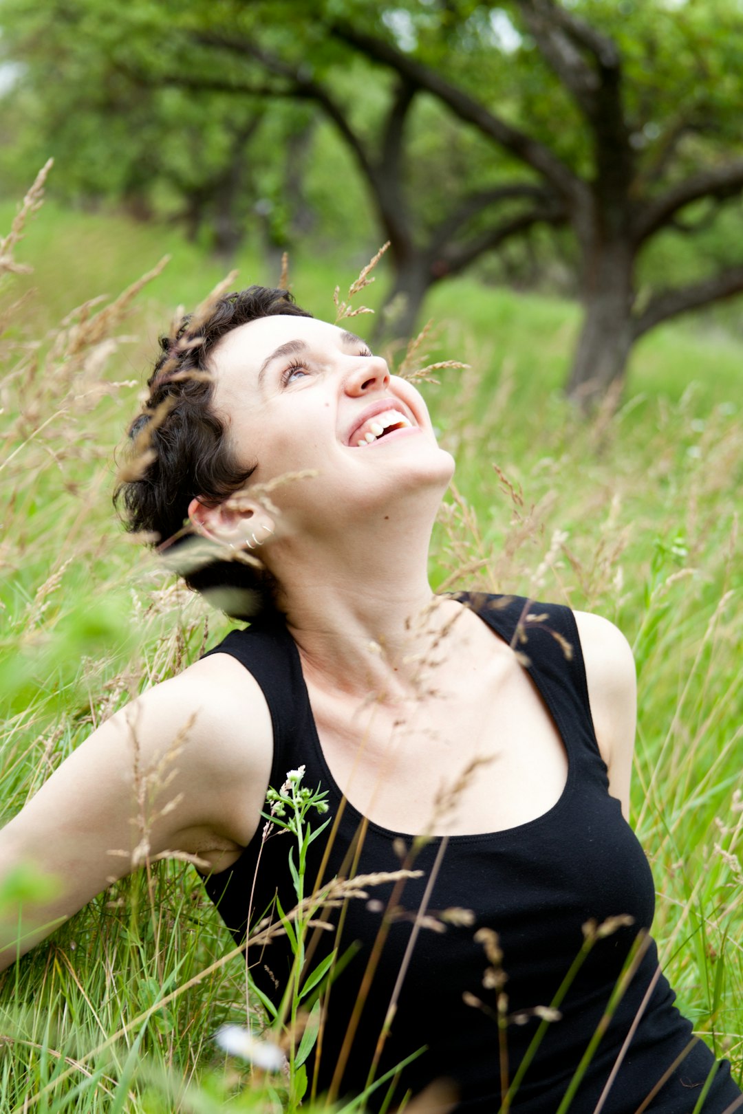 A woman laying in a field of tall grass