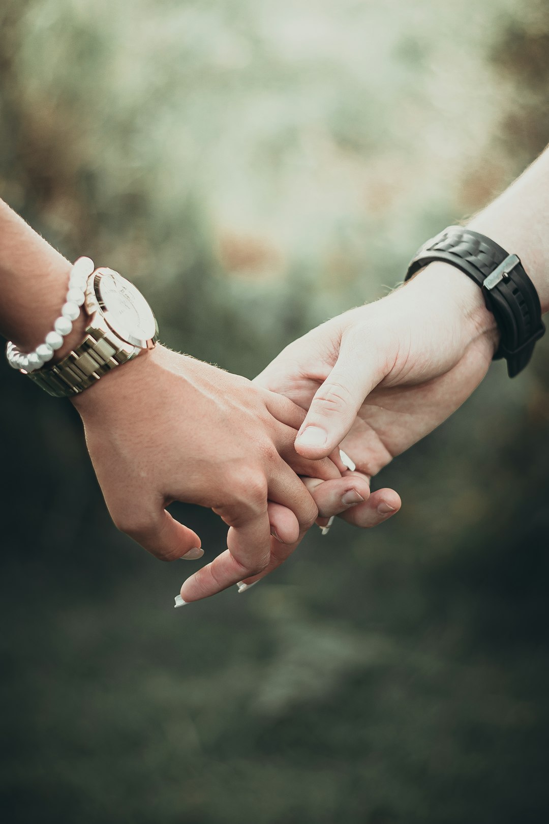 a close up of two people holding hands