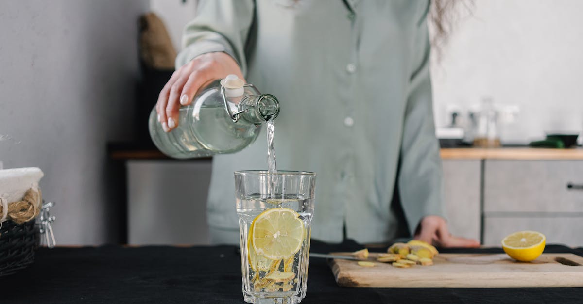 Woman pours water for lemon ginger infusion, promoting health and hydration.