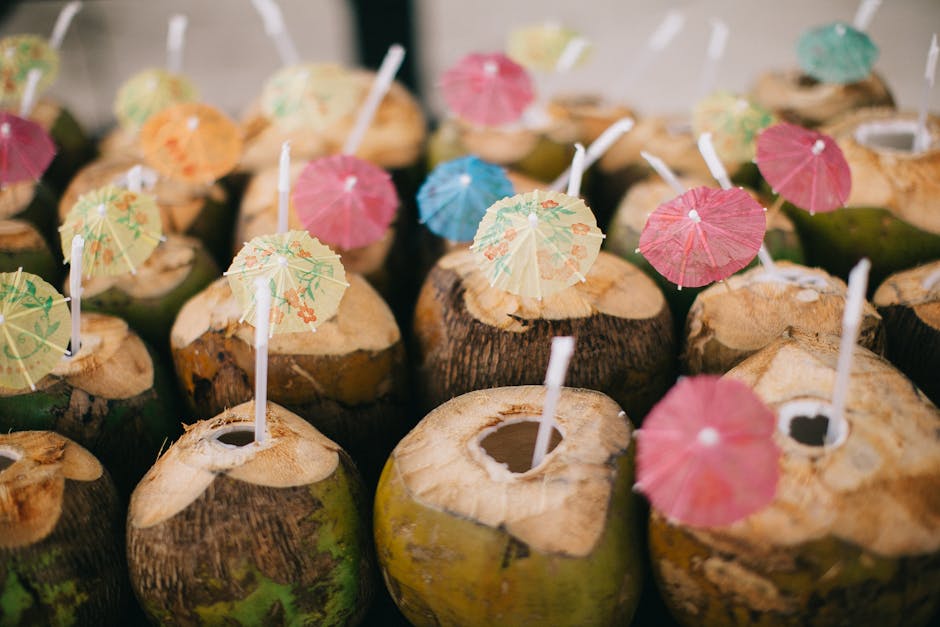 Fresh coconuts with straws and vibrant umbrellas, perfect for a tropical refreshment.